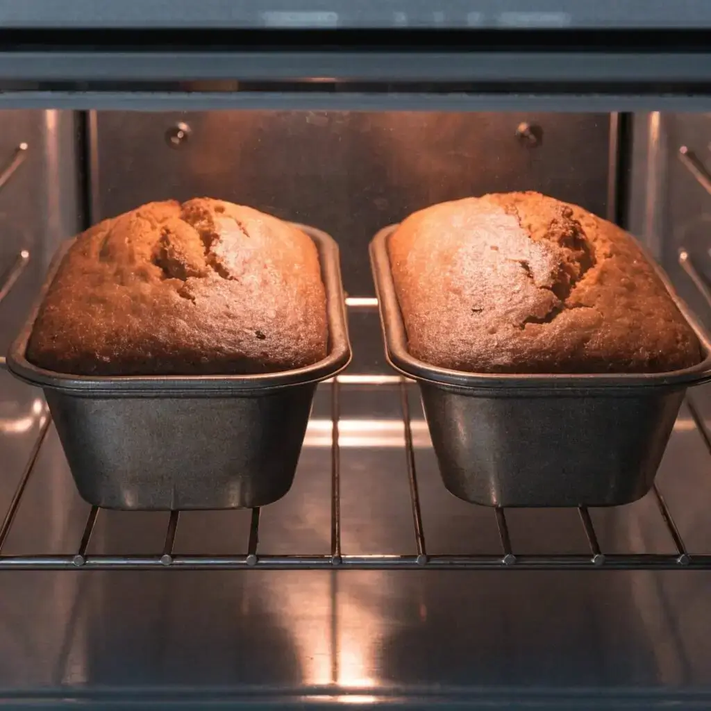 Sour cream banana bread loaves rising to golden perfection.